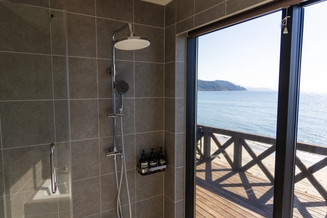 海を一望できるシャワールームとレインシャワー